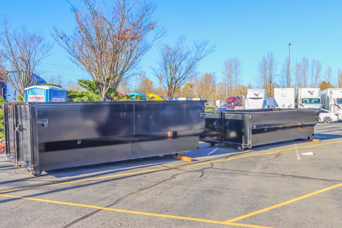 Professional dumpster rental service with roll-off container on residential driveway in Bennington